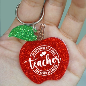 Close-up of glittery apple keychain with teacher appreciation quote on silver ring