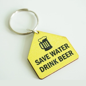 Detail of wooden house-shaped keychain with SAVE WATER DRINK BEER text and beer mug icon