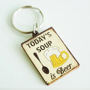 Detailed macro view of wooden keychain with Beer humor text and burnt edge texture