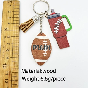 Detail of wooden mom keychain featuring football and tumbler charms with brown leather tassel
