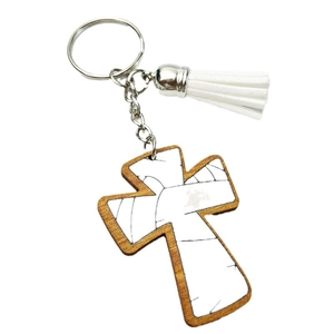 Detail of wooden cross keychain with marble pattern insert and white leather tassel