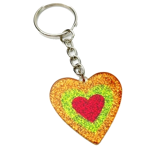 Close-up of heart-shaped keychain with neon glitter layers and silver metal ring