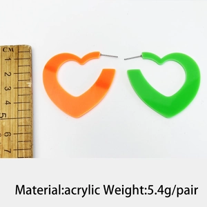 Détail de boucles d'oreilles cœur fluo en acrylique avec règle pour les dimensions