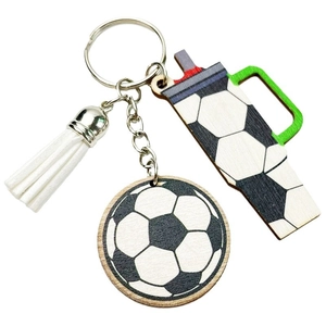 Close-up of wooden football keychain set with tumbler charm and white leather tassel