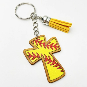 Detail of wooden cross keychain with baseball stitching pattern and yellow leather tassel