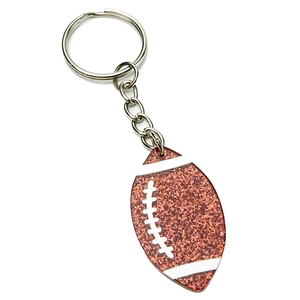 Porte-clés de football américain marron pailleté avec anneau en argent sur fond blanc
