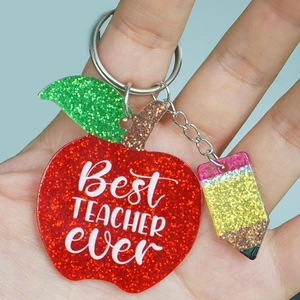 Close-up of glittery apple and pencil keychain with Best Teacher Ever printed text