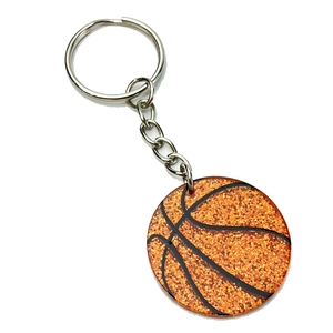 Vue détaillée d'un porte-clés basketball orange pailleté avec anneau en métal argenté
