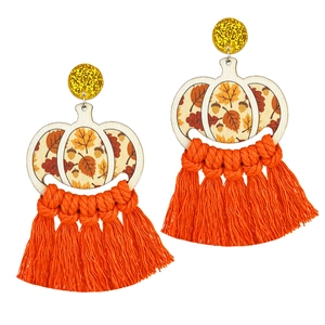 Detail of fall earrings with wooden pumpkin charms, maple leaves, and orange silk tassels