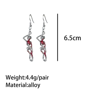 Macro detail of skeleton drop earrings with red enamel bone accents and hook design