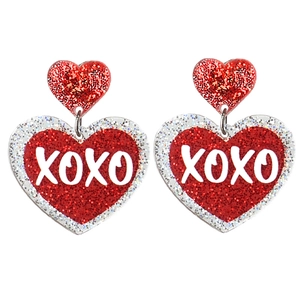 Detail of red glitter heart earrings with XOXO lettering for Valentine's Day parties