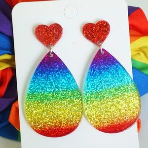Detail of glittery rainbow gradient heart and teardrop acrylic fringe earrings
