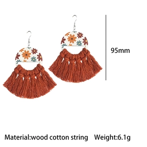 Detail of 95mm bohemian wood earrings with daisy print and terracotta cotton fringe