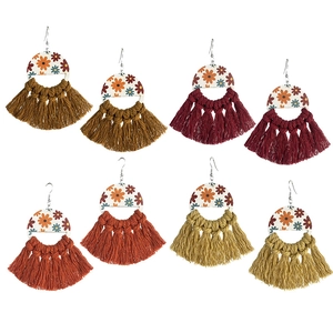 Detail of bohemian woven tassel earrings set in deep brown, burgundy, orange, and ginger colors