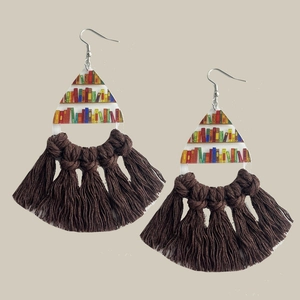 Dettaglio di orecchini bohémien con motivo libreria e nappe intrecciate marrone scuro