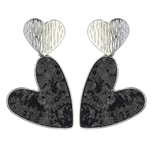 Détail de boucles d'oreilles double cœur en métal texturé argenté et paillettes noires