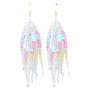 Détail de boucles d'oreilles longues à pompons avec paillettes scintillantes macaron