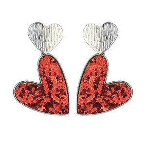 Détail macro de boucles d'oreilles cœur en métal argenté et paillettes rouges