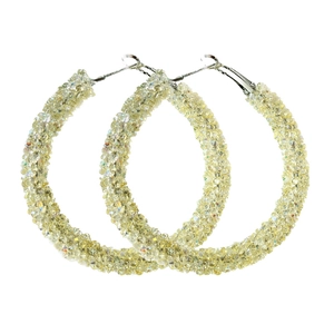 Macro detail of oversized hoop earrings fully encrusted with yellow sparkling crystals