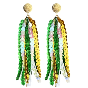 Detail of bohemian tassel earrings with green and yellow sequins on gold studs