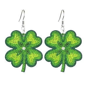 Detalle de pendientes de trébol verde brillante con cristal sobre fondo blanco