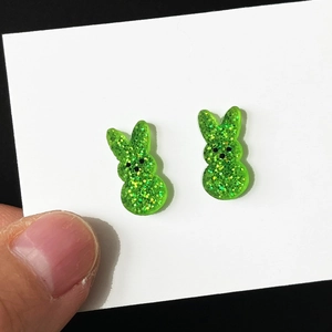 Detail of green glitter acrylic rabbit earrings showing scale and sparkling texture