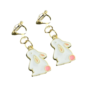 Detail of cute white rabbit clip-on earrings with gold trim and pink accents for girls