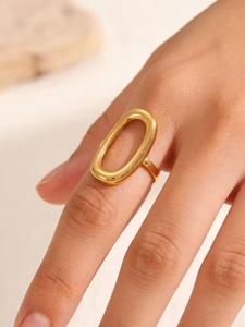 Detailopname van een minimalistische gouden ovale ring van roestvrij staal op model