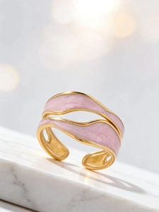 Detailed view of adjustable wavy gold ring with soft pink enamel inlay and minimalist curves