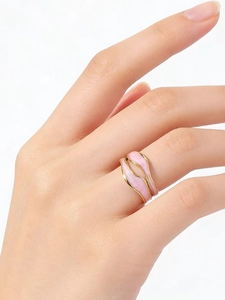 Detail of pink enamel wavy gold-plated stainless steel ring worn on the finger