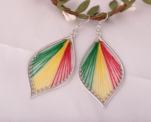 Dettaglio di orecchini boho a forma di foglia con fili di seta colorati intrecciati