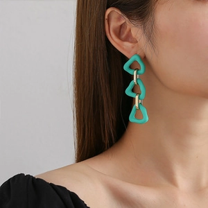 Detail of turquoise triple geometric teardrop earrings with gold links on model