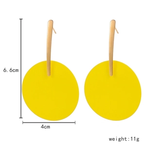 Detail view of yellow geometric earrings showing size 6.6cm and metal bar texture