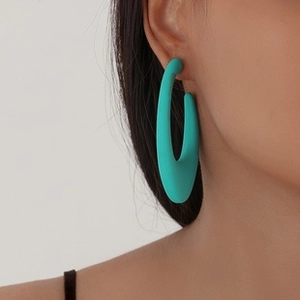 Close-up of model wearing large sky blue matte geometric hollow drop earrings