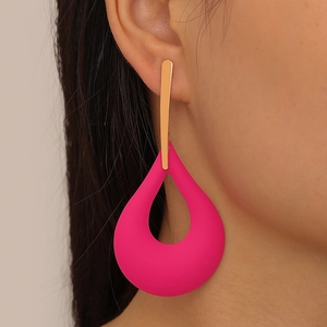 Close-up of matte rose pink oversized water drop earrings with golden stud on a model