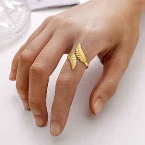 Close-up of golden leaf-shaped adjustable ring with intricate vein textures on a hand