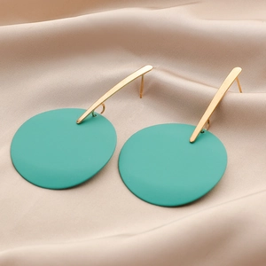 Macro view of turquoise matte lacquer earrings on champagne satin fabric background