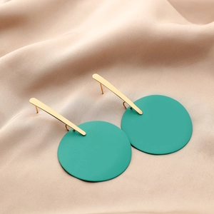 Detailed macro view of geometric earrings with gold bars and matte teal circular discs