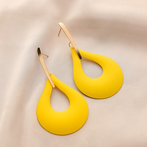 Macro view of matte yellow hollow teardrop earrings with gold metal top detail