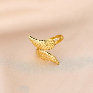 Detailed macro view of gold-plated leaf ring with intricate veins on silk background