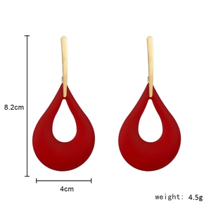 Detail view of large teardrop earrings with red hollow cutout and dimensions of 8.2cm x 4cm