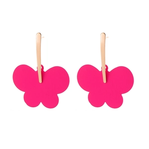 Macro view of oversized matte pink butterfly earrings with sleek golden metal studs