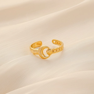 Detail of gold crescent moon and bead ring with textured chain band on beige silk