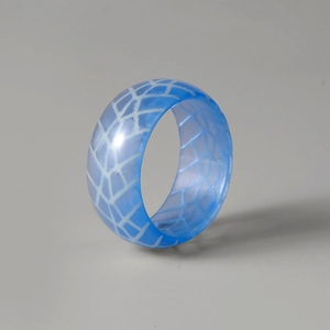 Makroaufnahme von blauem Harzring mit aufwendigen weißen geometrischen Gittermustern