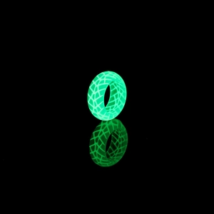 Detailaufnahme von leuchtendem Harzring mit Gittertextur, der im Dunkeln grün leuchtet