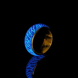 Leuchtender Ring mit blauem Rissmuster und goldener Metall-Innenseite im Detail