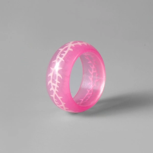 Détail macro de la bague en résine rose translucide avec motifs d'épines blanches Y2K