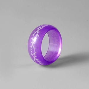 Détail de la bague en résine violette translucide avec texture d'épines blanches