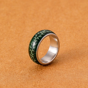 Detailaufnahme von leuchtendem grünem Harzring mit Dornenmuster und Edelstahl-Innenring