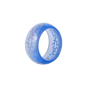 Bague en résine bleue lumineuse avec motif d'épines blanches sur fond blanc pur